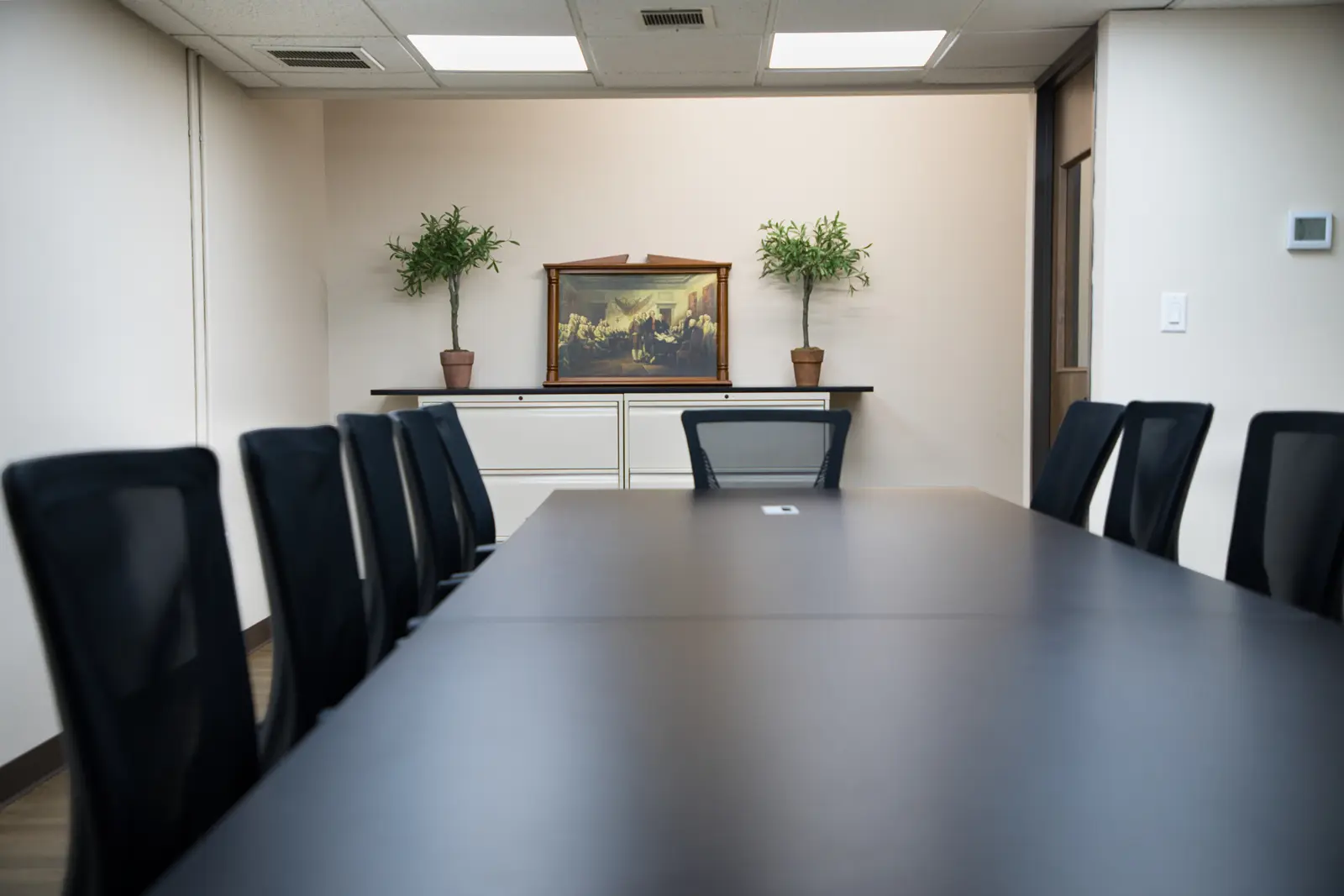 Conference Room from the head of the table, showing the credenza and framed artwork beyond