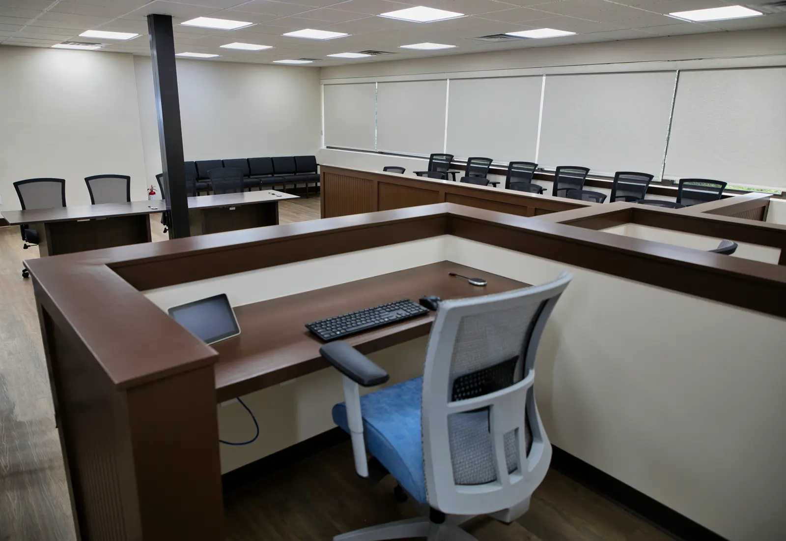 Mock Court Room counsel table with a keyboard-and-monitor workstation and gallery seating beyond